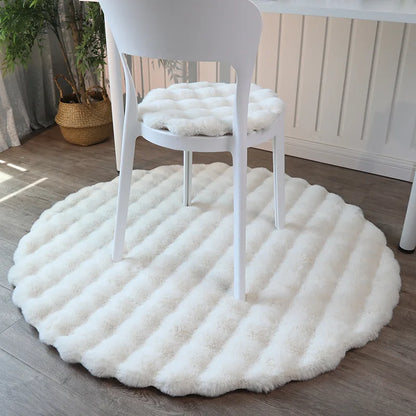 A snowy soft faux rabbit rug, showcasing a round shape and white fur, creating a cozy and inviting atmosphere.