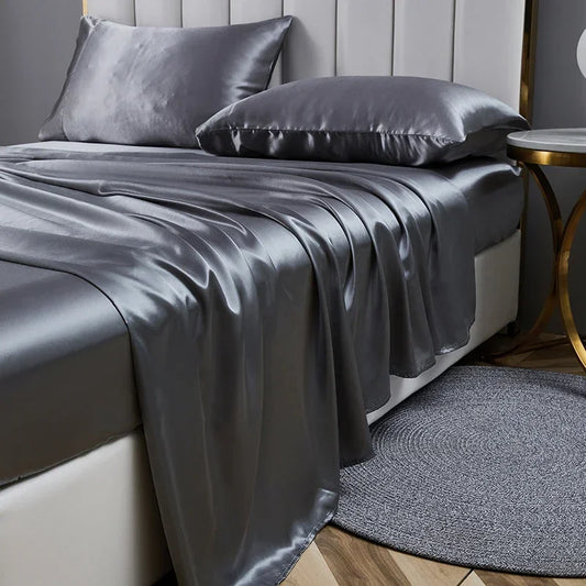 A luxurious bed adorned with a gray satin sheet, showcasing the elegance of the Opulent Satin Bed Sheet Set.