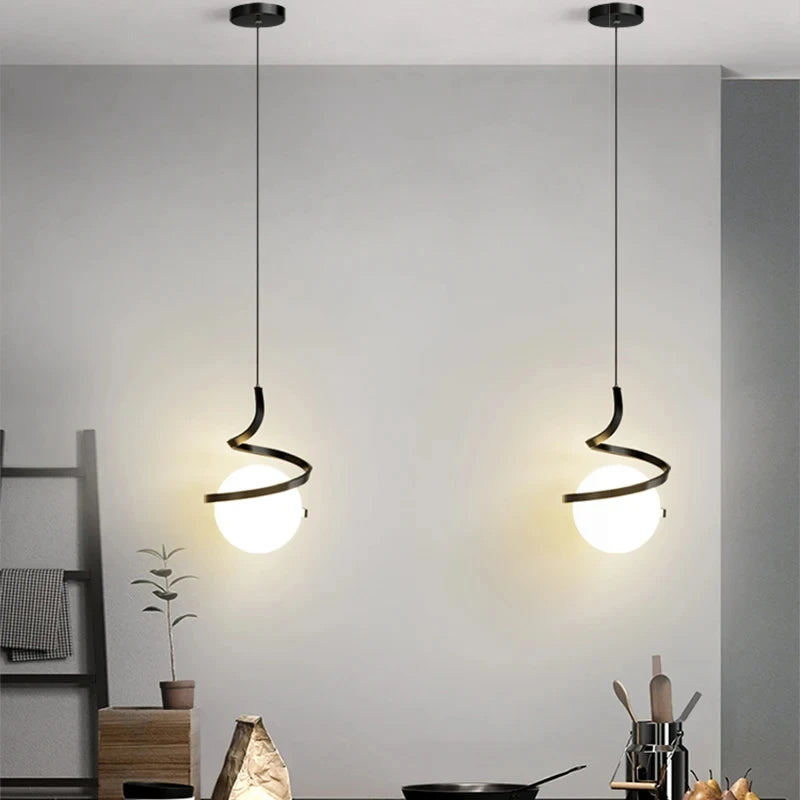 Two contemporary radiant pendant lights hanging from the ceiling in a modern kitchen.