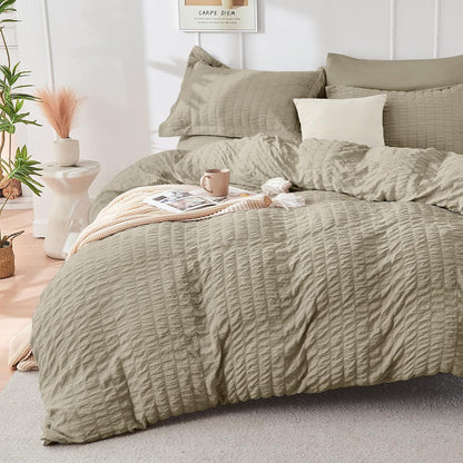 Green textured duvet set on a bed in a bedroom with plants and decor.
