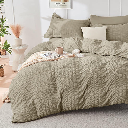 Green textured duvet set on a bed in a bedroom with plants and decor.