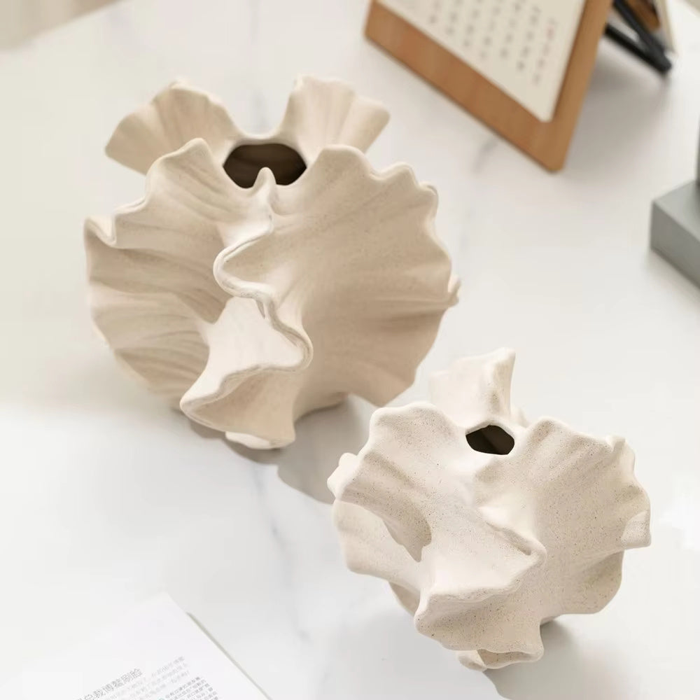 Side view of beige matte ceramic coral vase showing sculptural rippled edges