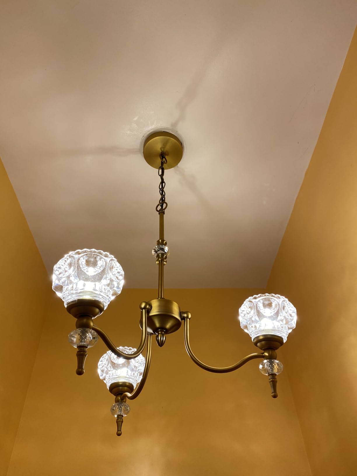 Vintage-style chandelier with glass shades hanging from a ceiling.