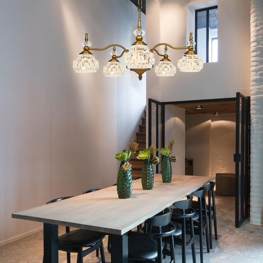 Modern dining room with a chandelier, table, and chairs.