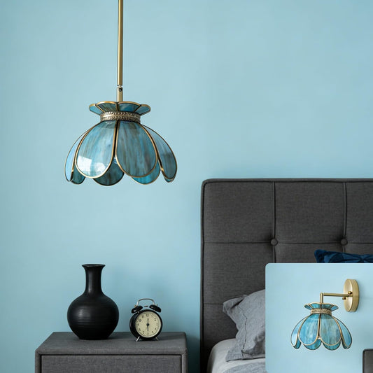 Decorative pendant light with a blue glass shade in a bedroom setting.