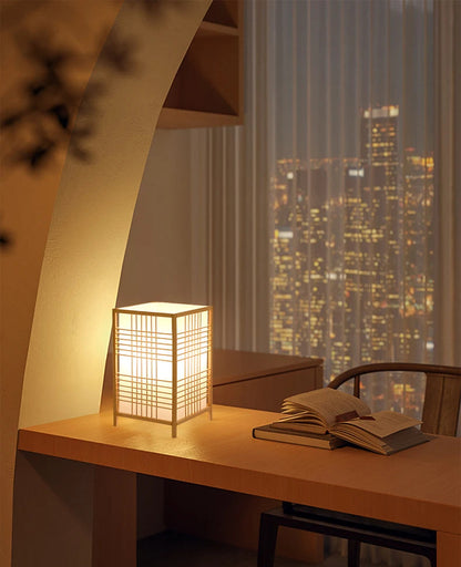 Table lamp on a desk with cityscape view through window