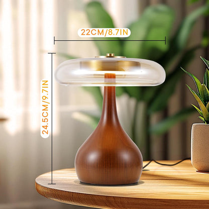 Table lamp with dimensions on a wooden surface with plants in the background