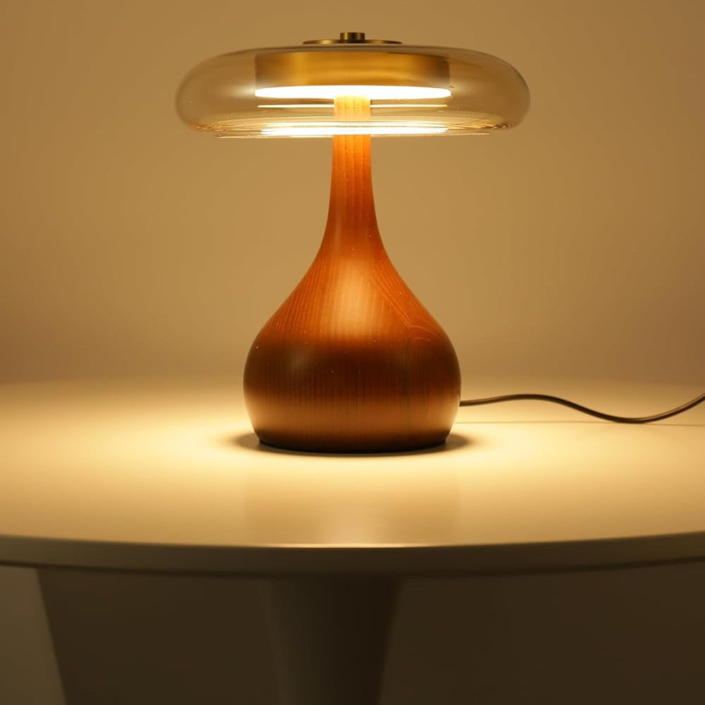 Table lamp with wooden base and glass shade on a neutral background