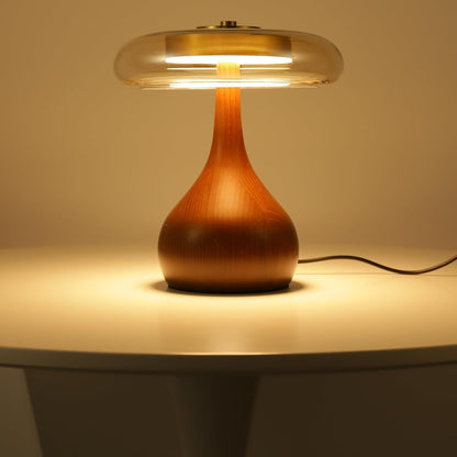 Table lamp with wooden base and glass shade on a neutral background