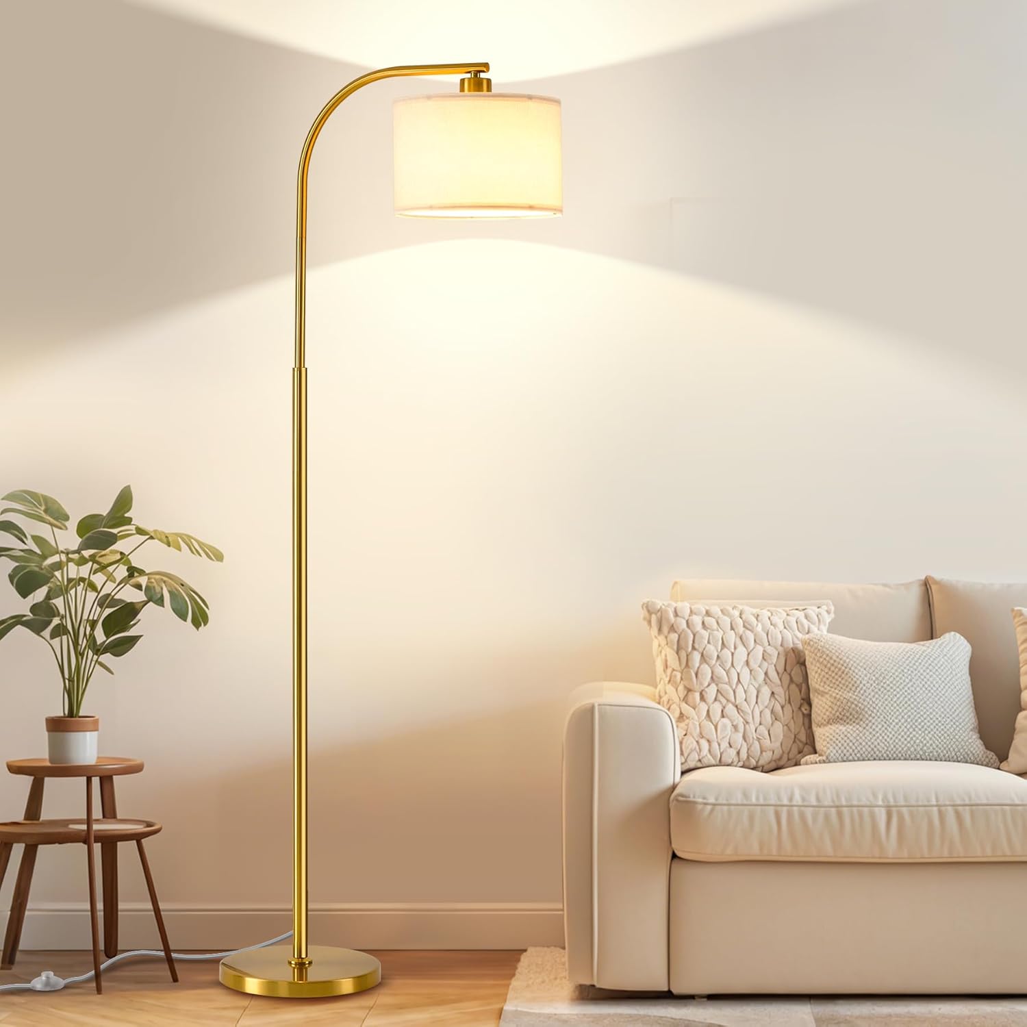 Gold floor lamp in a living room setting with a beige sofa and plant.