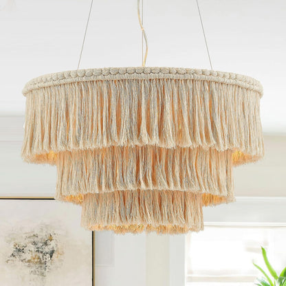 Macrame chandelier with fringes hanging against a white wall.