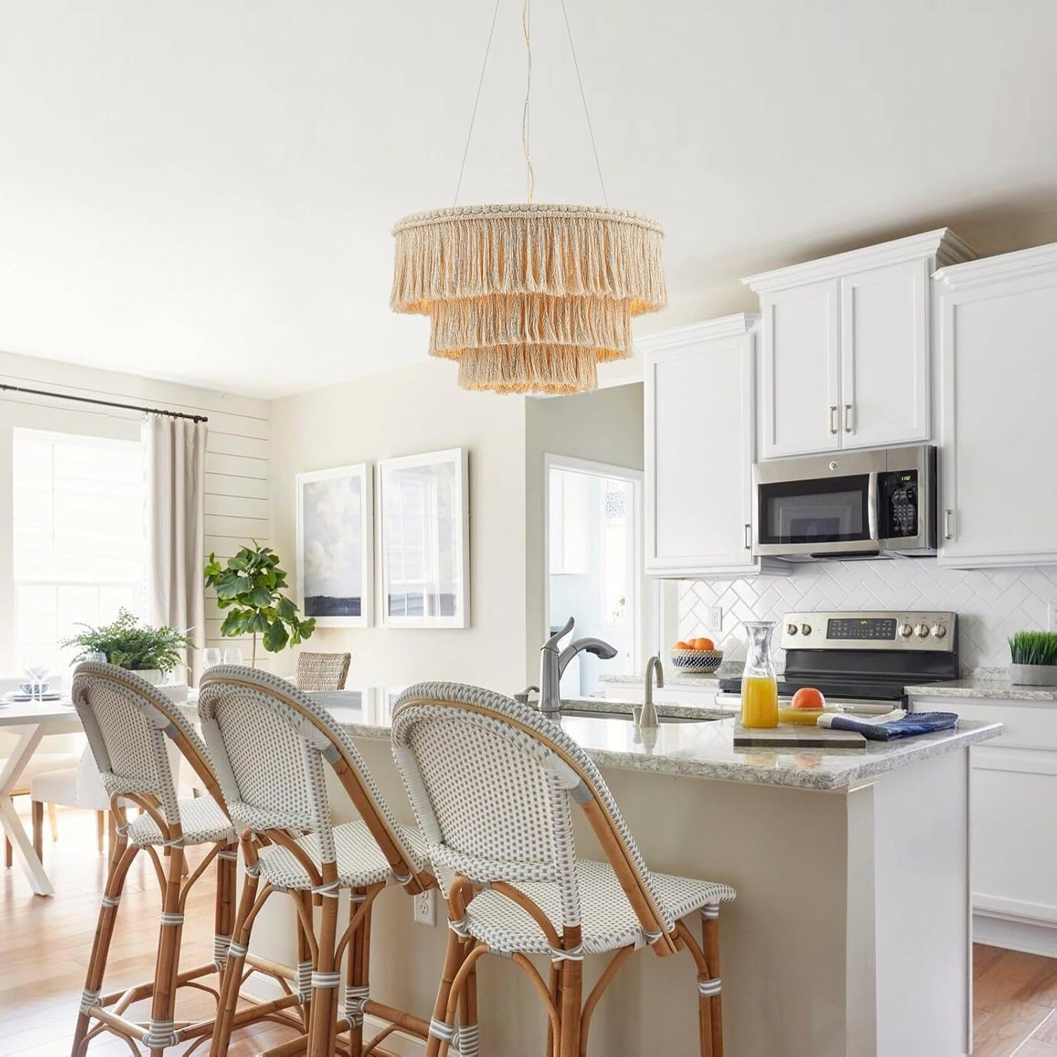 Modern kitchen with white cabinets, marble island, and rattan chairs.