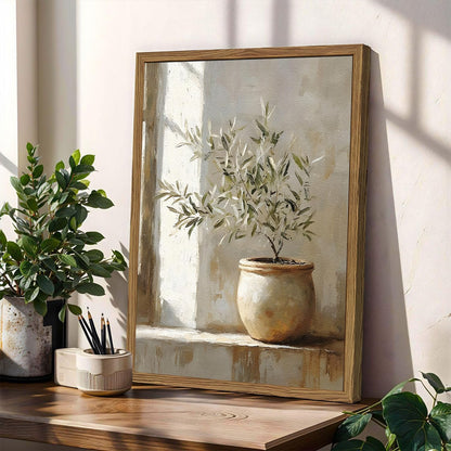 Framed artwork of a potted plant on a wooden surface with natural light.
