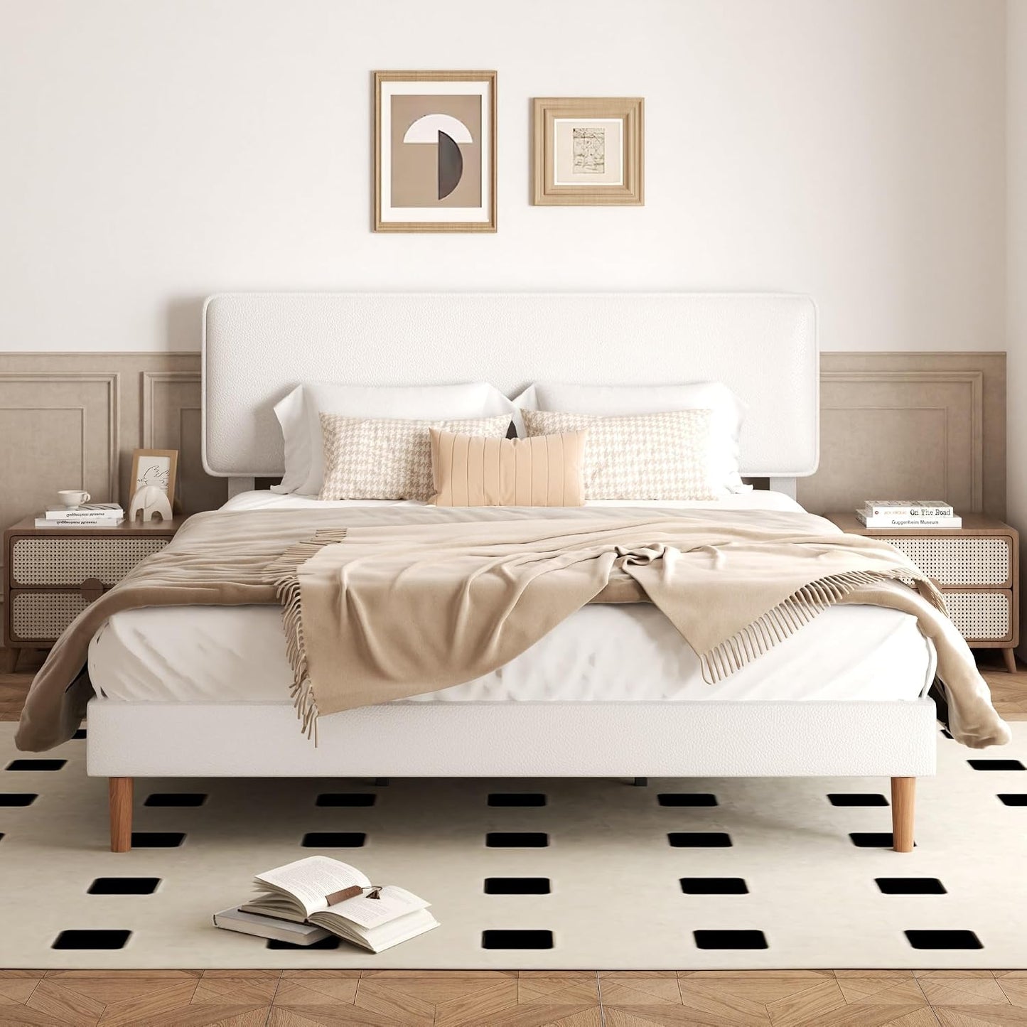 A modern white platform bed with a tall upholstered headboard, styled with beige and white bedding, wooden nightstands, framed wall art, and a black-and-white checkered rug in a neutral bedroom setting.