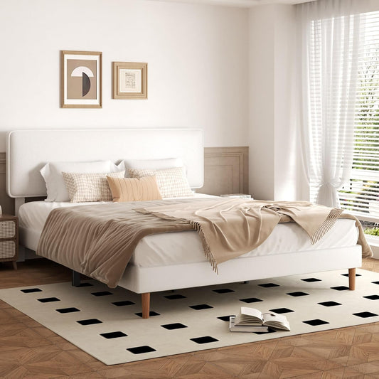 Modern bedroom with a white bed, beige blanket, and patterned rug.