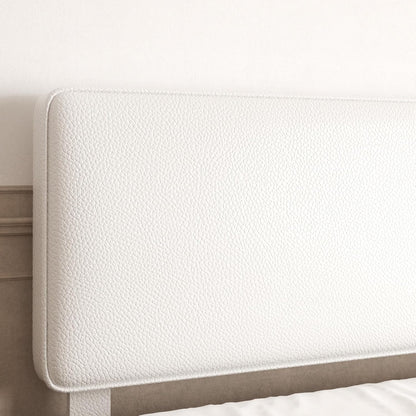 Close-up of a white upholstered headboard with a textured pebbled leather or faux-leather finish, shown against a light neutral wall.