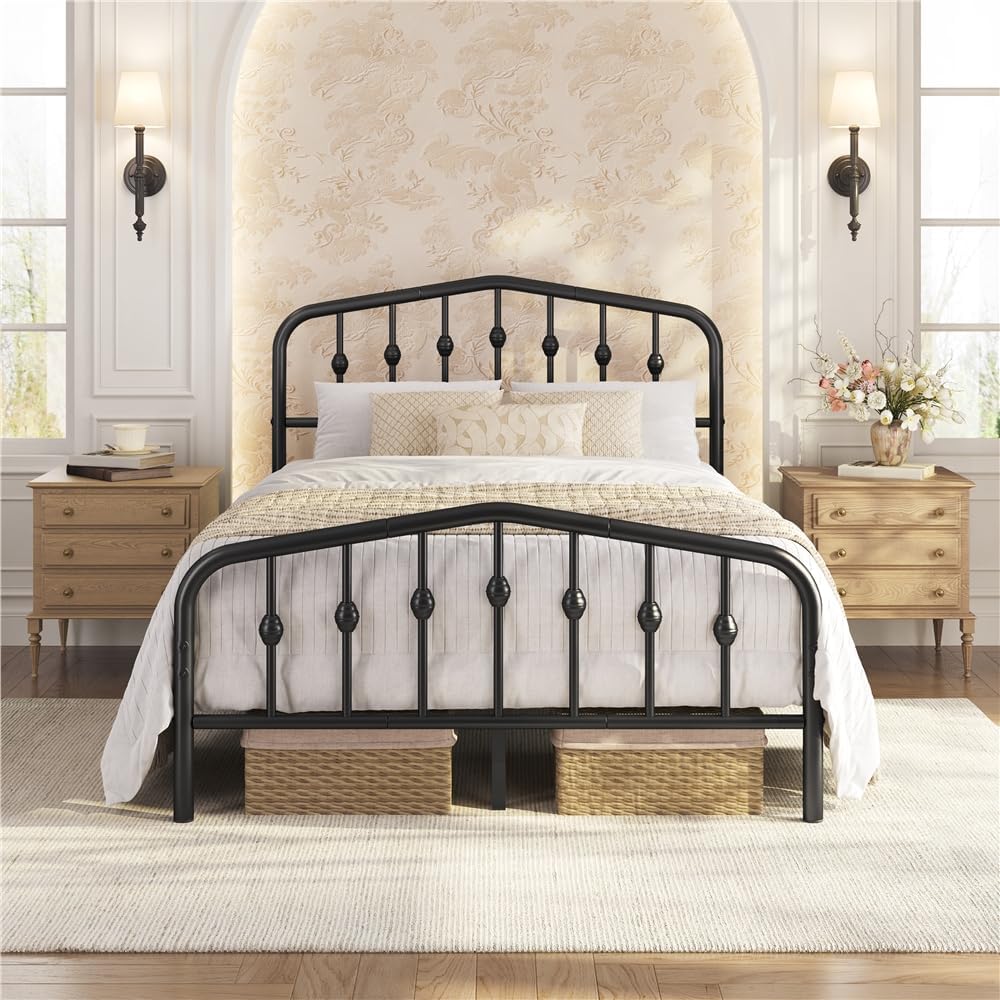 A black metal bed frame with an arched headboard and footboard, styled in a bright, symmetrical bedroom with light wood nightstands, beige wallpaper, and white bedding.