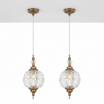 Two gold pendant lights with clear glass shades on a white background