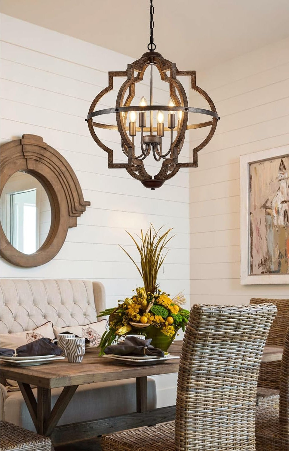 Dining room with a rustic pendant light, wooden table, and wicker chairs.