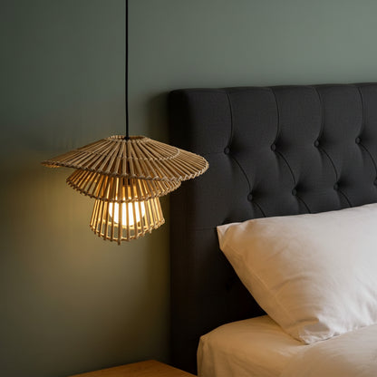 Woven pendant light hanging above a bed with wooden headboard