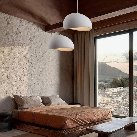 Modern bedroom with a bed, pendant lights, and large windows overlooking a scenic view.