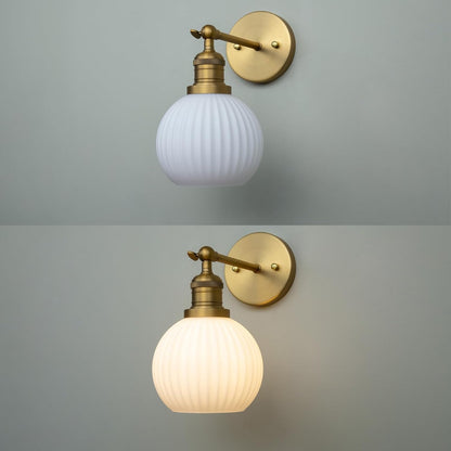 Two wall sconces with glass globe shades on a gray background