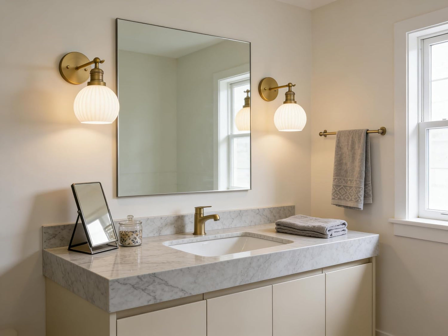 Bathroom vanity with mirror, lights, and towels