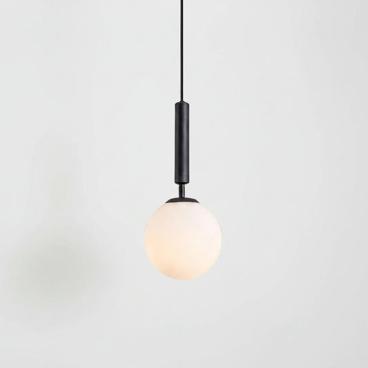 Two black pendant lights with spherical frosted white glass shades hanging over a modern white kitchen. A larger close-up of one light is shown on the left, and the other is shown in situ on the right.