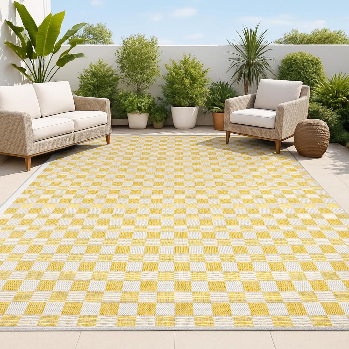 Yellow and white checkered rug on a patio with outdoor furniture and plants.