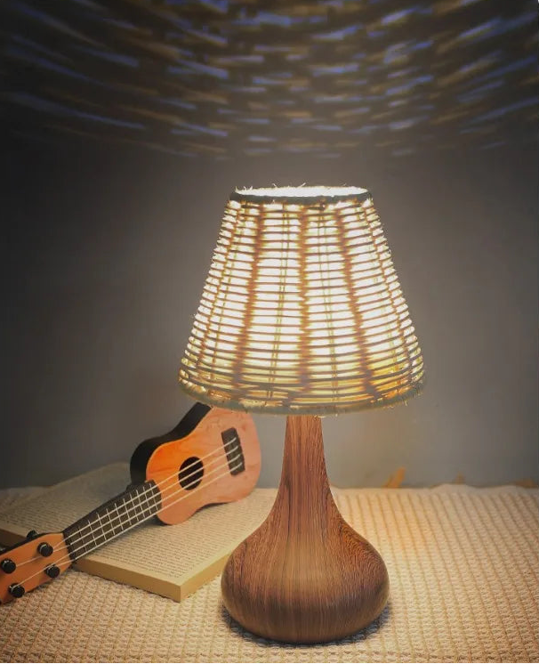 Wicker table lamp with guitar and book on a textured surface