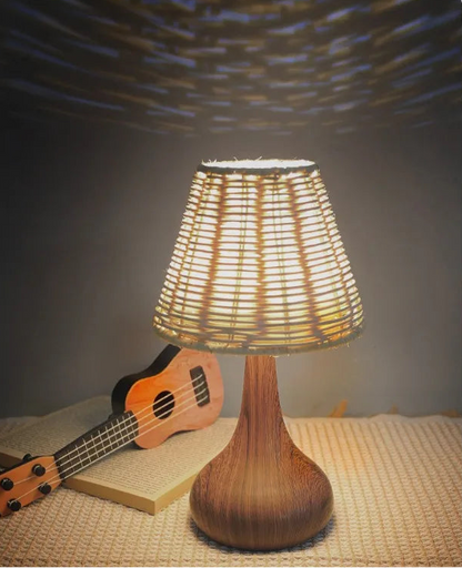 Wicker table lamp with guitar and book on a textured surface