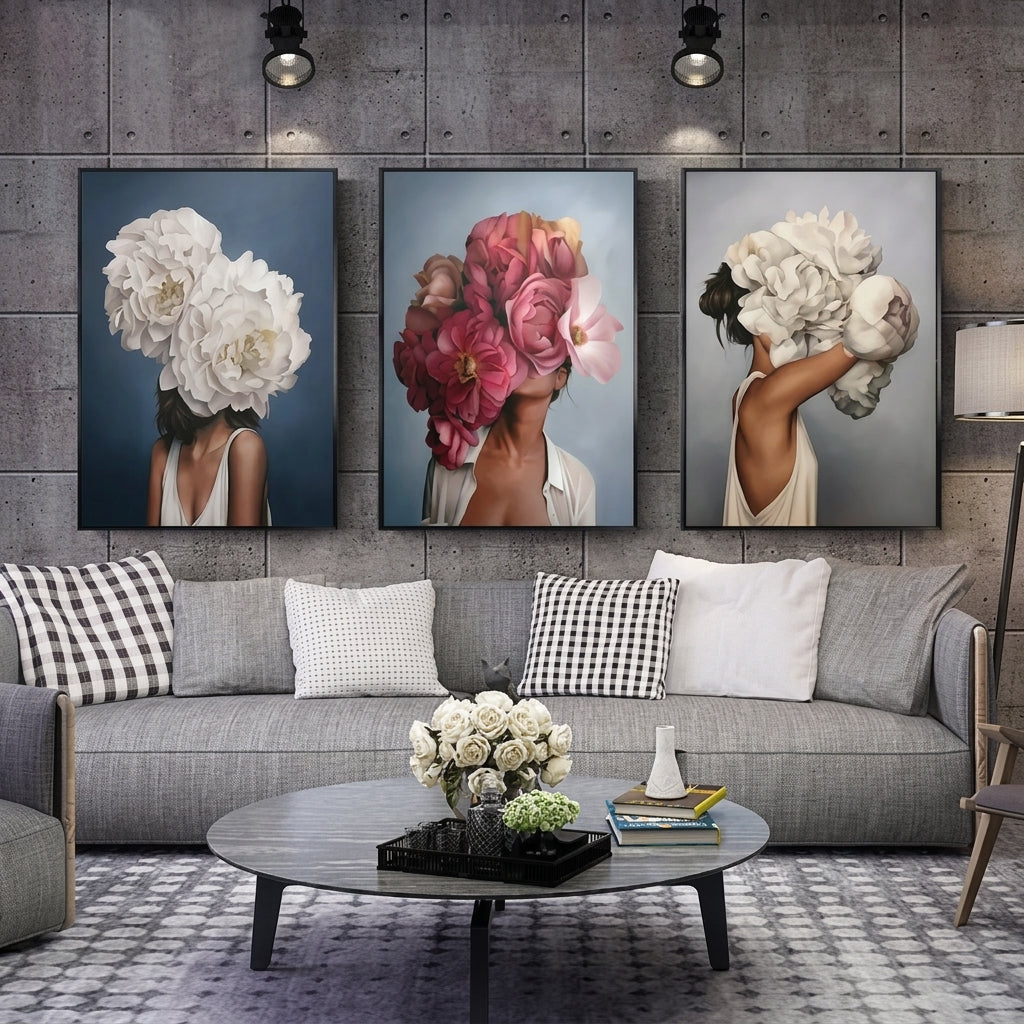 Three framed wall art prints depicting women with large flower heads are displayed above a gray sofa in a modern living room setting.