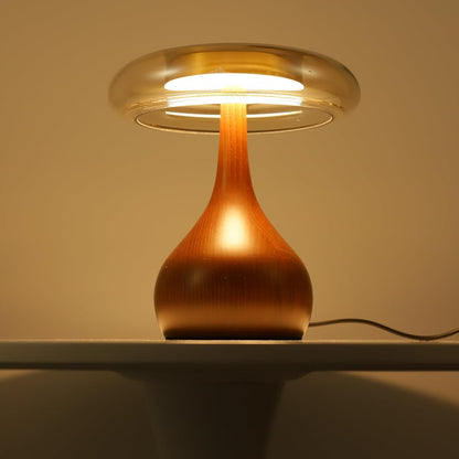 Wooden table lamp with a warm glow on a white surface against a beige wall.