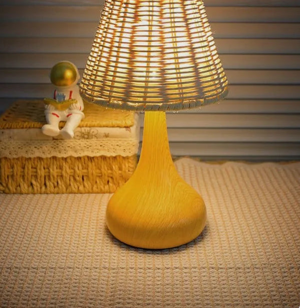 Yellow table lamp with woven shade on a textured surface