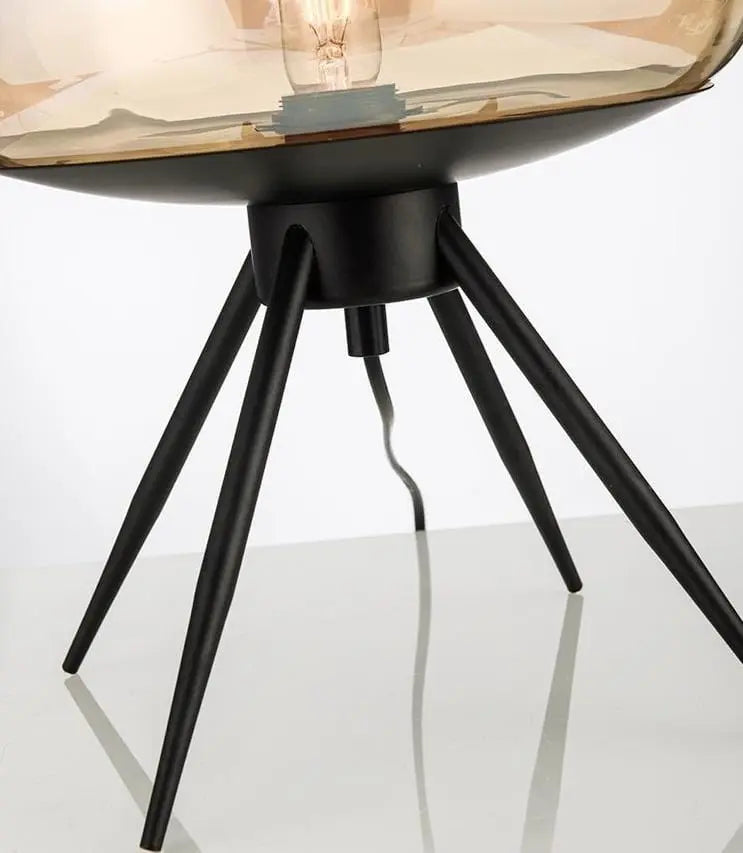 Modern table lamp with a glass shade and black metal base on a white background