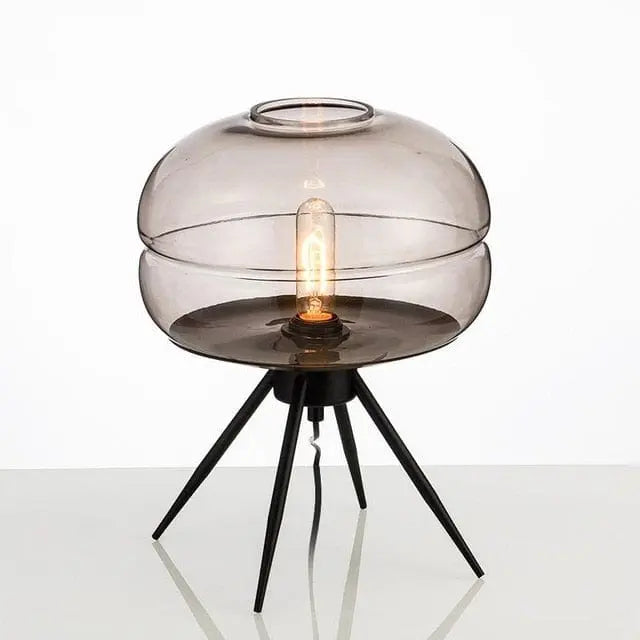 Modern table lamp with smoked glass shade and black metal base on a white background