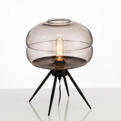 Modern table lamp with smoked glass shade and black metal base on a white background